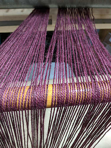 Warp threads running over supporting rod